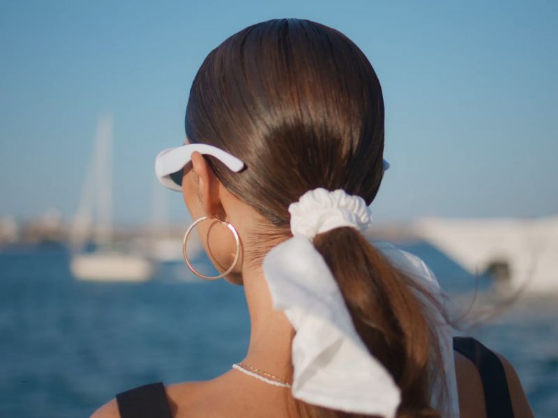 devojka sa aksesoarom na repu, naočarama i minnđušama se slika pored mora