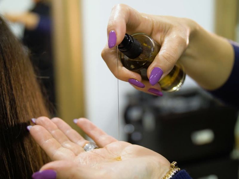 osoba nanosi kosu na kokosovo ulje