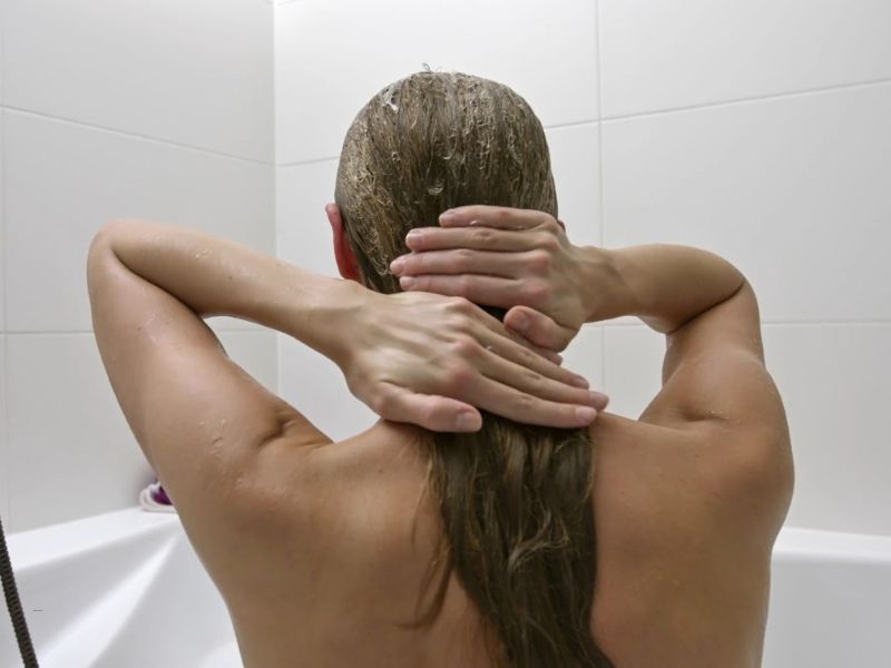 devojka stavlja masku od kokosovog ulja na kosu