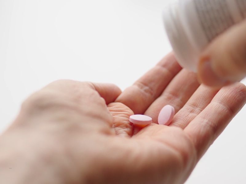 devojka stavlja na dlan vitamine za kosu