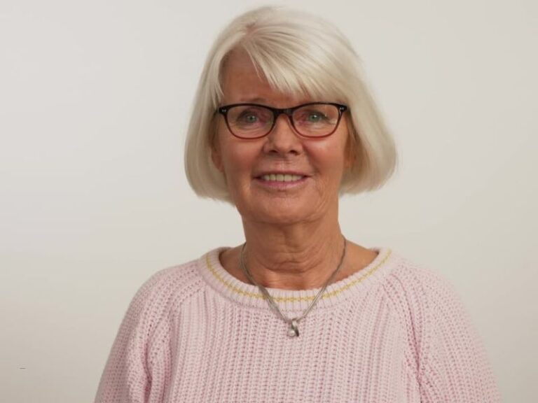 žena sede kose sa kratkom paž frizurom se smeši sa naočarima na licu